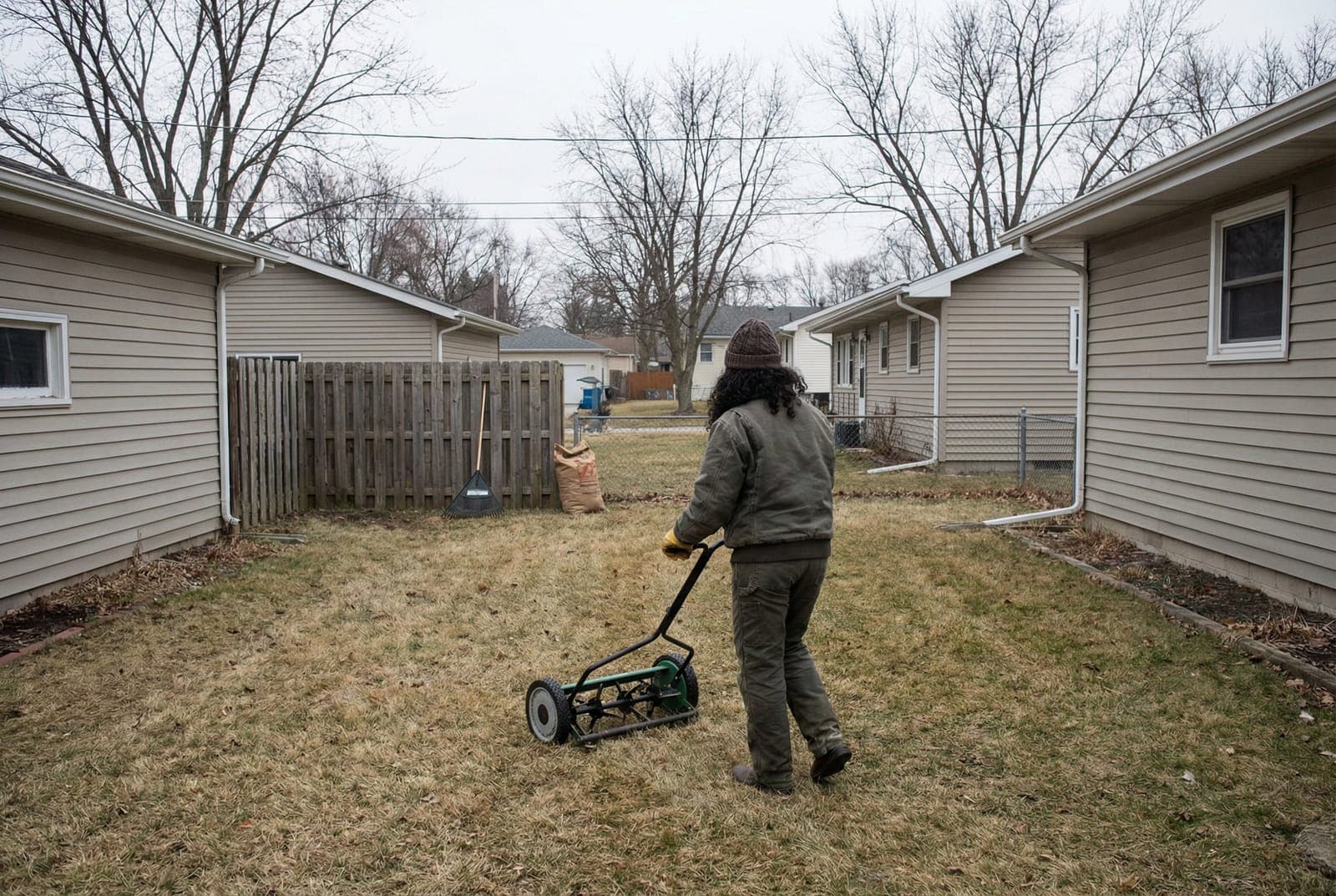 Professional landscaper repairing dead grass patches with fresh soil and new grass seed in a residential lawn